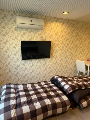 a bedroom with two beds and a tv on the wall at The Asakusa Townhouse in Tokyo
