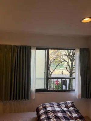 a bedroom with a bed and a window with a view at The Asakusa Townhouse in Tokyo