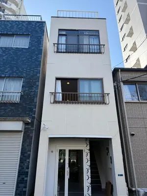 a white building with two balconies and a door at The Asakusa Townhouse in Tokyo