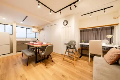 a kitchen and a living room with a table and chairs at Yuka House Komagome 1\u968e \u81ea\u8ee2\u8eca\u4ed8 \u304a\u3082\u3061\u3083\u3068\u843d\u66f8\u304d\u58c1\u306e\u30d7\u30ec\u30a4\u30eb\u30fc\u30e0 \u5bb6\u65cf\u5411\u3051 in Tokyo