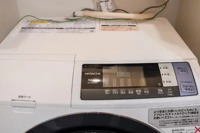 a washing machine with a digital clock on top of it at Yuka House Komagome 1\u968e \u81ea\u8ee2\u8eca\u4ed8 \u304a\u3082\u3061\u3083\u3068\u843d\u66f8\u304d\u58c1\u306e\u30d7\u30ec\u30a4\u30eb\u30fc\u30e0 \u5bb6\u65cf\u5411\u3051 in Tokyo