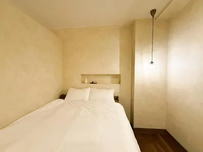 a bedroom with a white bed in the corner at 52 House Shimbashi in Tokyo