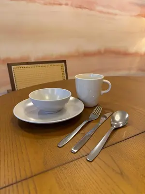 a table with two bowls and a cup and a fork and knife at 52 House Shimbashi in Tokyo
