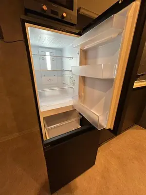 an empty refrigerator with its door open in a kitchen at Domo Stay in Tokyo