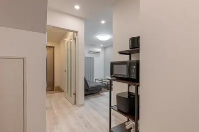 a room with a microwave and a living room at -Imado- Within walking distance of Asakusa Station and Tokyo Skytree! in Tokyo