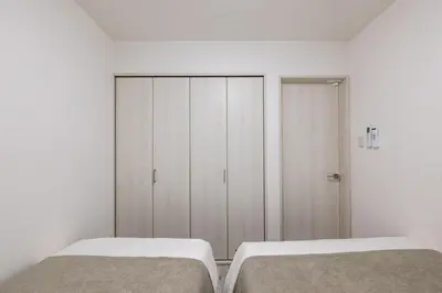 a white bedroom with two beds and a closet at -Imado- Within walking distance of Asakusa Station and Tokyo Skytree! in Tokyo