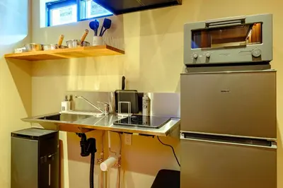 a small kitchen with a sink and a microwave at Yolo Asakusa Stay in Tokyo