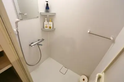 a white bathroom with a shower with bottles of wine at Newly Renovated & Yamanote Line Sugamo 7 Minute Walk in Tokyo