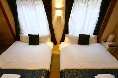two beds in a room with two windows at Newly Renovated & Yamanote Line Sugamo 7 Minute Walk in Tokyo