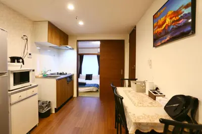 a kitchen with a table and a room with a bed at Newly Renovated & Yamanote Line Sugamo 7 Minute Walk in Tokyo