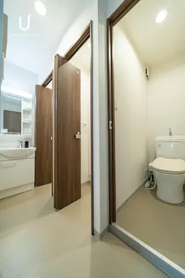 a bathroom with a toilet and a sliding glass door at unito villa SHINJUKU in Tokyo