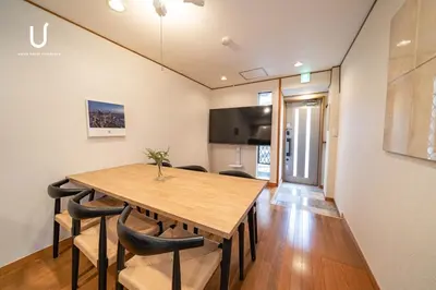 a dining room with a wooden table and chairs at unito villa SHINJUKU in Tokyo