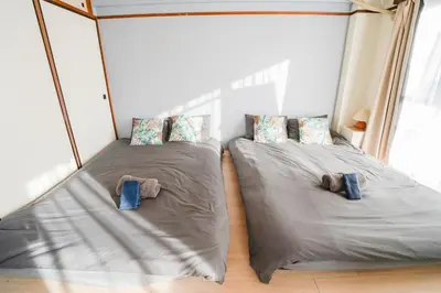 two twin beds in a room with windows at 403Room 1 Stop from Ikebukuro Entire 35m on 4st Floor 2 Bedrooms for up to 6 Guests 3Minute Walk to Don Quijote in Tokyo