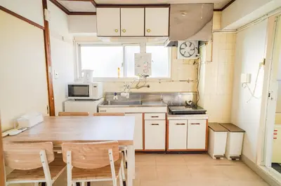 a kitchen with a wooden table and a sink at 403Room 1 Stop from Ikebukuro Entire 35m on 4st Floor 2 Bedrooms for up to 6 Guests 3Minute Walk to Don Quijote in Tokyo