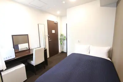 a room with a bed and a desk and a computer at HOTEL LiVEMAX Higashi Ginza in Tokyo