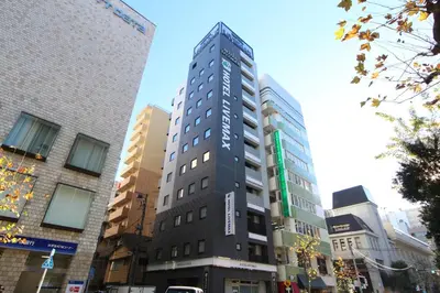 a tall building in the middle of a city at HOTEL LiVEMAX Higashi Ginza in Tokyo