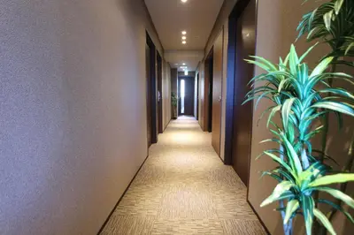 a corridor in a hotel with plants on the walls at HOTEL LiVEMAX Higashi Ginza in Tokyo