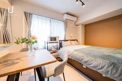 a hotel room with a bed and a table and a dining room at unito residence SHINJUKU Wakamatsu in Tokyo