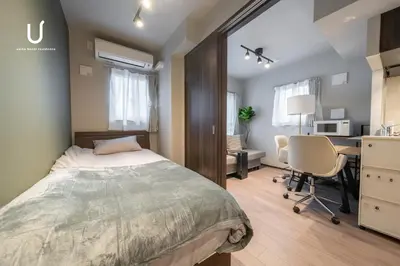 a bedroom with a bed and a desk and a computer at unito residence SHINJUKU Wakamatsu in Tokyo