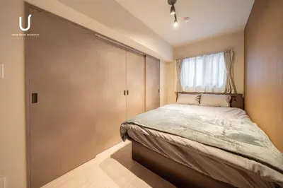 a small bedroom with a bed and a window at unito residence SHINJUKU Wakamatsu in Tokyo