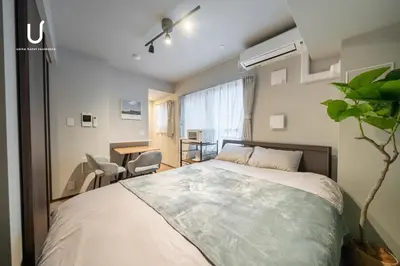 a bedroom with a bed and a table and chairs at unito residence SHINJUKU Wakamatsu in Tokyo