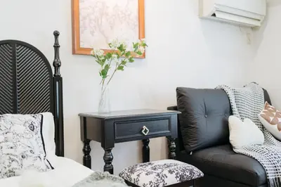a living room with a chair and a table with a vase on it at \u6771\u65b0\u5bbf-Shinjuku Area-Max3P-Vintage Style-St 3mins in Tokyo