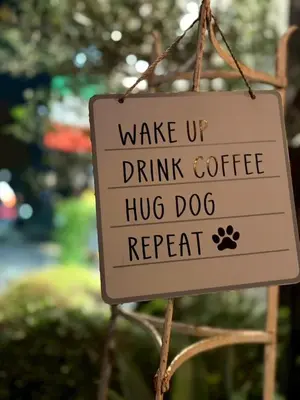 a sign that reads wake up drink coffee hug dog repeat at Runbull House in Tokyo