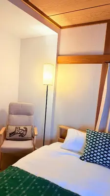 a bedroom with a bed and a chair and a lamp at Higashi-Jujo-house \u7950\u6cfd KI0478 in Tokyo