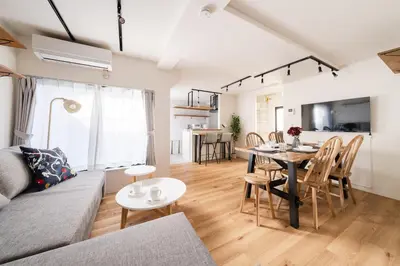 a living room with a couch and a table at Yuka House Komagome 2\u968e \u81ea\u8ee2\u8eca\u4ed8 \u304a\u3082\u3061\u3083\u3068\u843d\u66f8\u304d\u58c1\u306e\u30d7\u30ec\u30a4\u30eb\u30fc\u30e0 \u5bb6\u65cf\u5411\u3051 in Tokyo