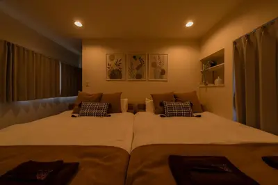 two twin beds in a room with two pillows at Yuka House Komagome 2\u968e \u81ea\u8ee2\u8eca\u4ed8 \u304a\u3082\u3061\u3083\u3068\u843d\u66f8\u304d\u58c1\u306e\u30d7\u30ec\u30a4\u30eb\u30fc\u30e0 \u5bb6\u65cf\u5411\u3051 in Tokyo