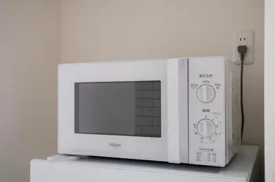 a white microwave oven sitting on top of a counter at Yuka House Komagome 2\u968e \u81ea\u8ee2\u8eca\u4ed8 \u304a\u3082\u3061\u3083\u3068\u843d\u66f8\u304d\u58c1\u306e\u30d7\u30ec\u30a4\u30eb\u30fc\u30e0 \u5bb6\u65cf\u5411\u3051 in Tokyo