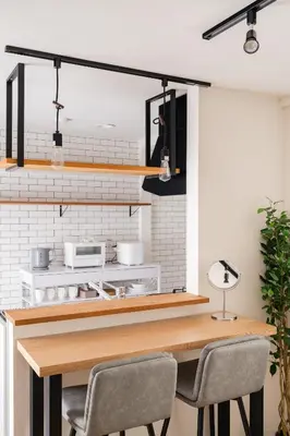 a kitchen with a wooden table and chairs at Yuka House Komagome 2\u968e \u81ea\u8ee2\u8eca\u4ed8 \u304a\u3082\u3061\u3083\u3068\u843d\u66f8\u304d\u58c1\u306e\u30d7\u30ec\u30a4\u30eb\u30fc\u30e0 \u5bb6\u65cf\u5411\u3051 in Tokyo