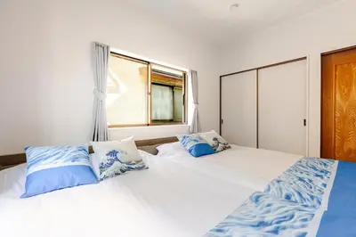 a bedroom with two beds with blue and white pillows at Nnb\u938c\u50094\u4e01\u76ee in Tokyo