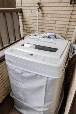 a large white cooler sitting next to a brick wall at Nnb\u938c\u50094\u4e01\u76ee in Tokyo