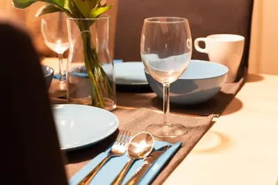 a table with plates and forks and spoons and wine glasses at Imb\u753a\u5c4b4\u4e01\u76ee302 in Tokyo