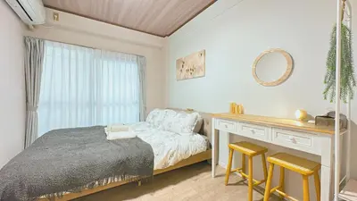 a bedroom with a bed and a desk with two stools at SAKURA HOUSE 206, Sakura Shinmachi St 2 min walk, Shibuya 10 min, Free WiFi in Tokyo