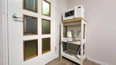 a microwave oven sitting on a shelf next to a door at SAKURA HOUSE 206, Sakura Shinmachi St 2 min walk, Shibuya 10 min, Free WiFi in Tokyo