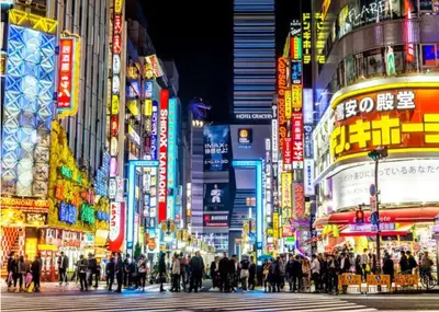 a crowd of people crossing a busy city street at night at -Baba 3chome- 8-minute walk from Takadanobaba station in Tokyo