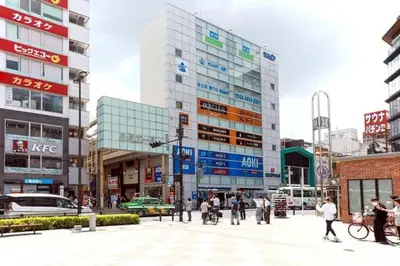 a group of people walking in a city with buildings at Kaga house1 in Tokyo
