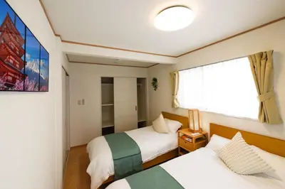 a small room with two beds and a window at Kaga house1 in Tokyo