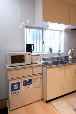 a kitchen with a microwave and a sink at Kaga house1 in Tokyo