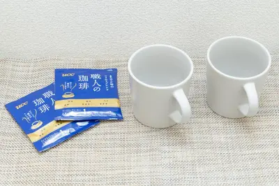 two white cups sitting next to a credit card at The House IKEBUKURO 301 in Tokyo