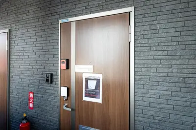 a wooden door in a building with a brick wall at The House IKEBUKURO 301 in Tokyo