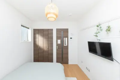 a bedroom with a bed and a flat screen tv at The House IKEBUKURO 301 in Tokyo