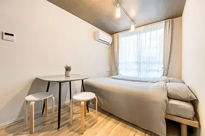 a small bedroom with a bed and a table at Casa-T\u4e94\u53cd\u91ce in Tokyo