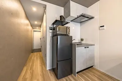 a small kitchen with a refrigerator and a microwave at Casa-T\u4e94\u53cd\u91ce in Tokyo