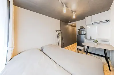 a bedroom with a bed and a table in a kitchen at Casa-T\u4e94\u53cd\u91ce in Tokyo