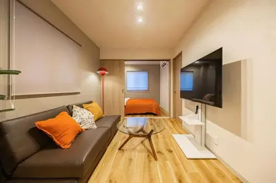 a living room with a couch and a tv at Lino Stay Kasai 'elua in Tokyo