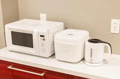 a microwave and a coffee maker on a counter at Lino Stay Kasai 'elua in Tokyo
