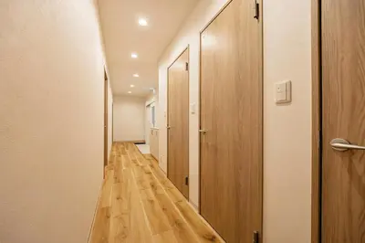 a hallway with wood floors and a hallway with doors at Lino Stay Kasai 'elua in Tokyo